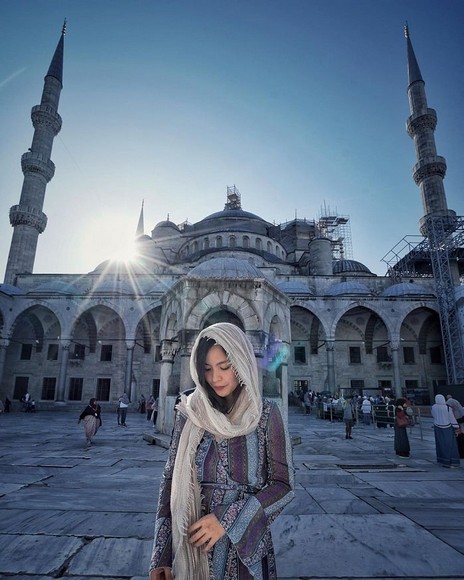 Nữ du khách trùm khăn lụa màu be đứng trước Nhà Thờ Hồi Giáo Xanh ở Istanbul